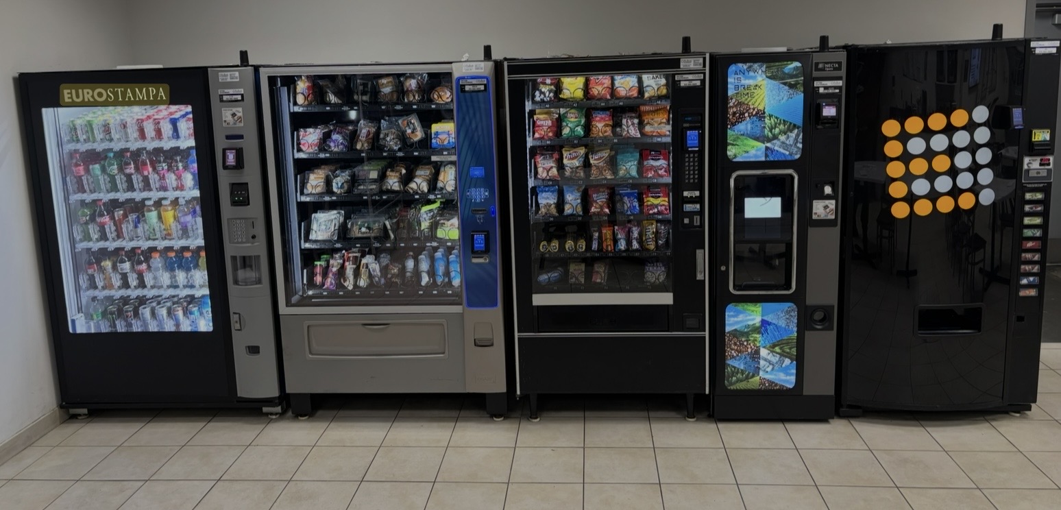 Row of modern traditional vending machines — snack, beverage, and combination units